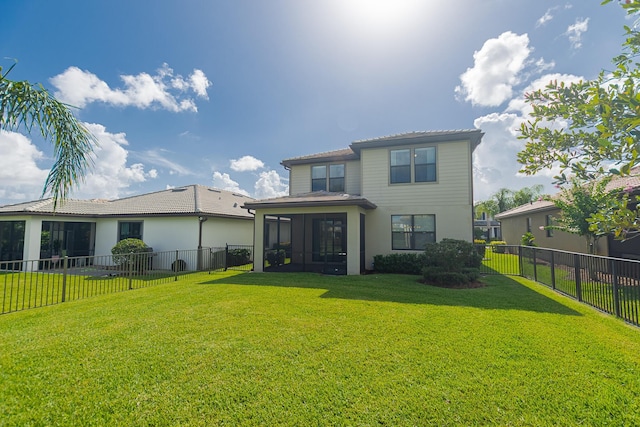 rear view of house with a yard and a sunroom