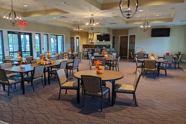 carpeted dining space featuring crown molding, a raised ceiling, a chandelier, and french doors