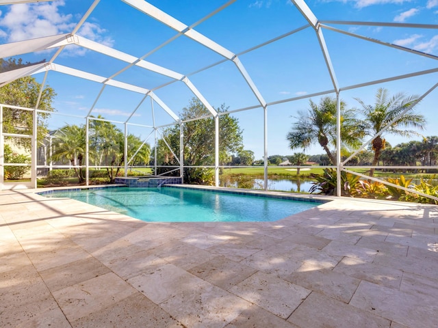 view of pool with glass enclosure, a patio area, and a water view