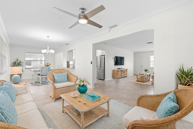 living room with crown molding, plenty of natural light, light tile patterned floors, and ceiling fan with notable chandelier