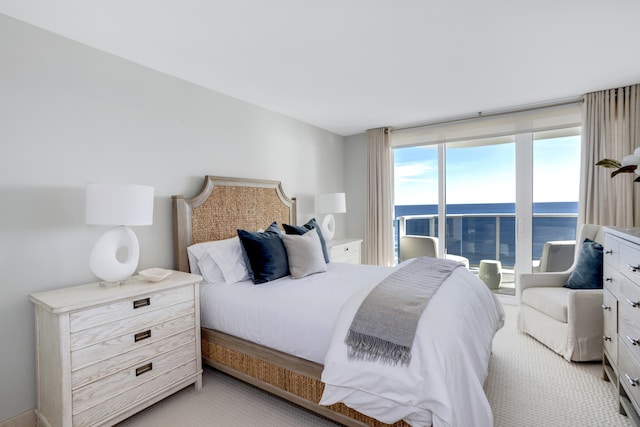 bedroom with a water view and light colored carpet