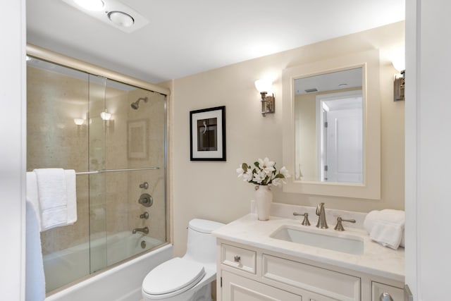 full bathroom featuring shower / bath combination with glass door, vanity, and toilet