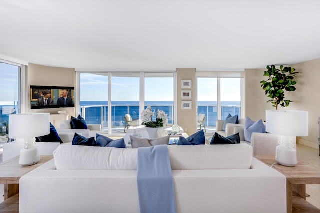 living room with a wall of windows, a water view, and plenty of natural light