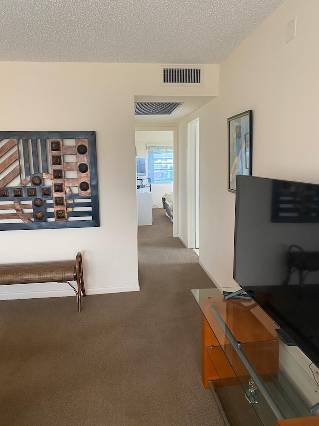 hallway with dark colored carpet and a textured ceiling