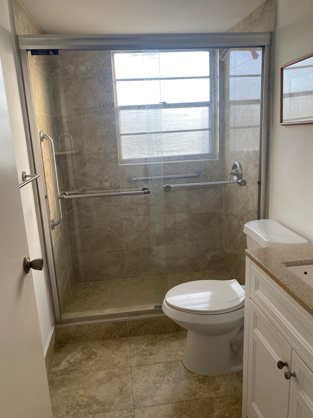 bathroom featuring walk in shower, vanity, and toilet