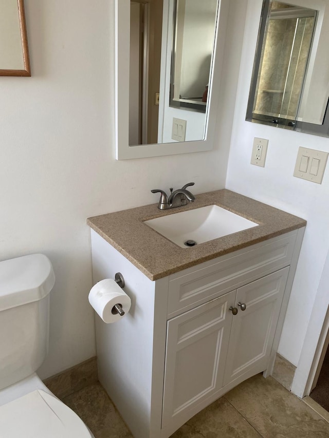 bathroom with tile patterned floors, vanity, and toilet