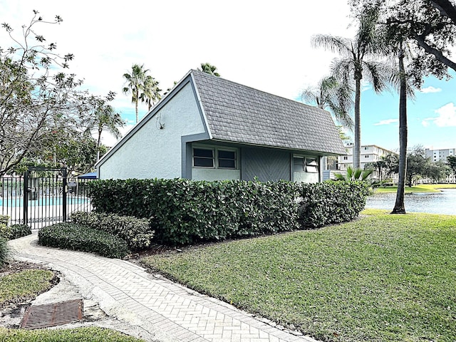 view of side of home with a fenced in pool and a yard