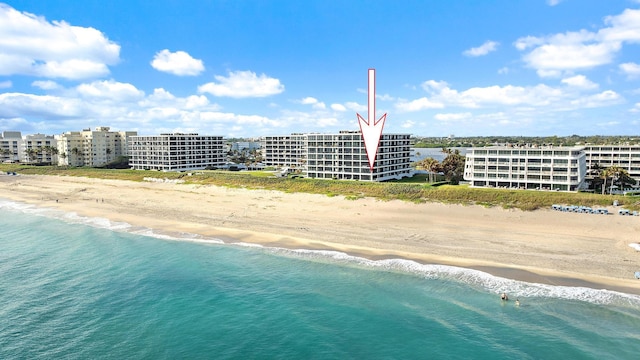 birds eye view of property featuring a beach view and a water view