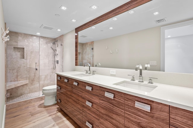 bathroom with hardwood / wood-style floors, vanity, toilet, and an enclosed shower