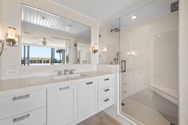 bathroom with an enclosed shower, hardwood / wood-style floors, vanity, and ceiling fan