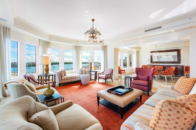 living room with a water view, a chandelier, and a tray ceiling