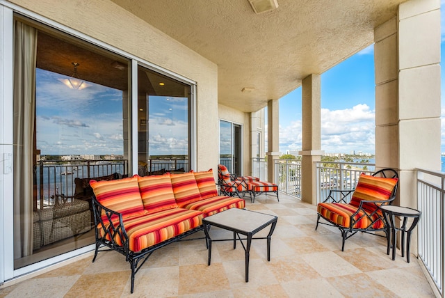 view of patio / terrace with a balcony and a water view