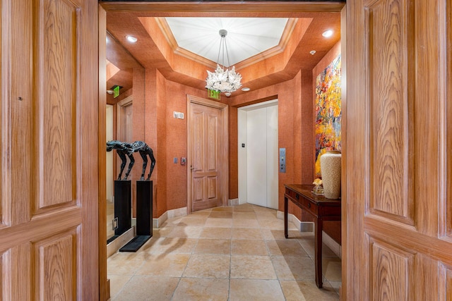 interior space featuring a raised ceiling, crown molding, elevator, and a notable chandelier