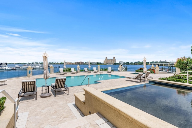 view of pool featuring a water view and a patio area