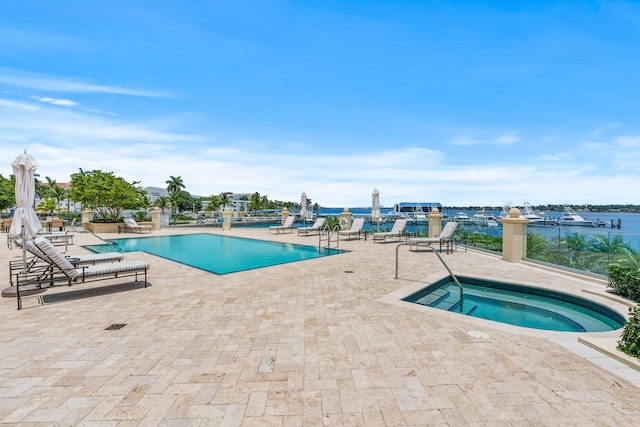 view of pool with a water view, a community hot tub, and a patio area