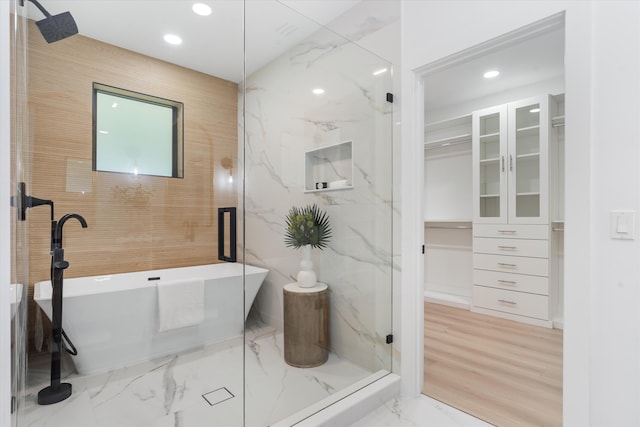 bathroom with tile walls and shower with separate bathtub