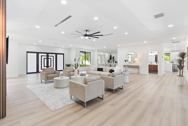 living room featuring ceiling fan, light hardwood / wood-style flooring, and a healthy amount of sunlight