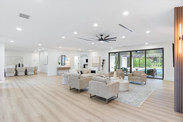 living room with light hardwood / wood-style floors and ceiling fan