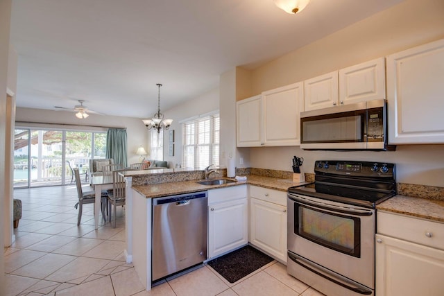 kitchen featuring light tile patterned flooring, sink, white cabinetry, kitchen peninsula, and stainless steel appliances