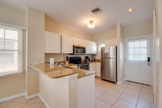 kitchen with light tile patterned flooring, appliances with stainless steel finishes, sink, white cabinets, and kitchen peninsula