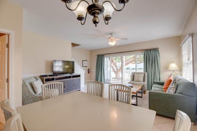 tiled dining area with ceiling fan with notable chandelier