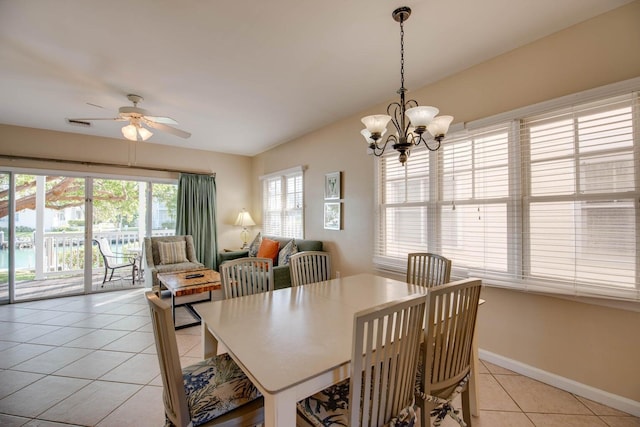 tiled dining room with ceiling fan with notable chandelier