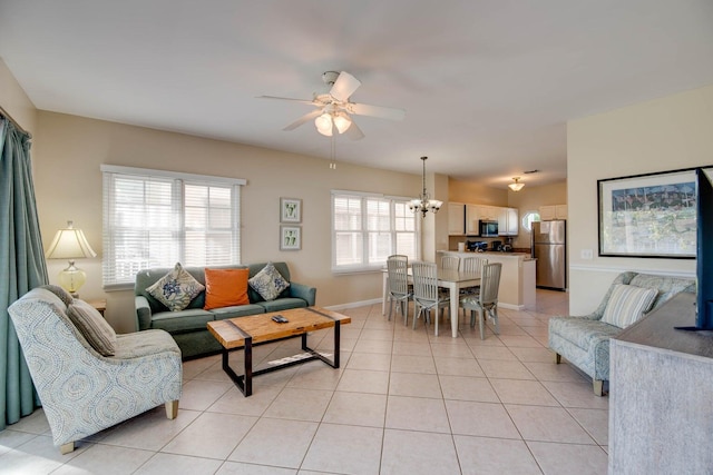 living room featuring ceiling fan with notable chandelier and light tile patterned floors