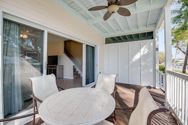 sunroom with beamed ceiling and ceiling fan