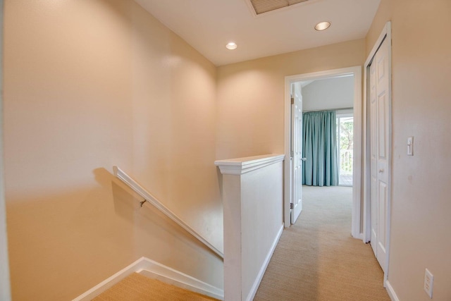 hallway featuring light colored carpet