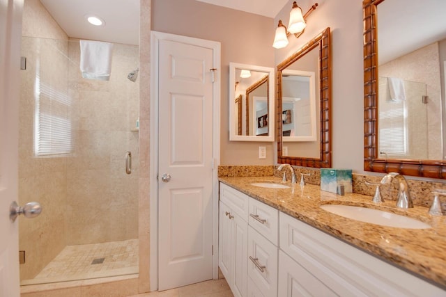 bathroom featuring a shower with door, vanity, and tile patterned floors