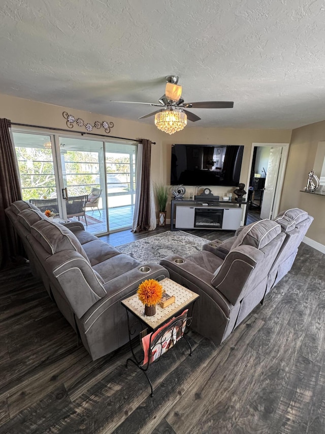 living room with ceiling fan, dark hardwood / wood-style flooring, and a textured ceiling