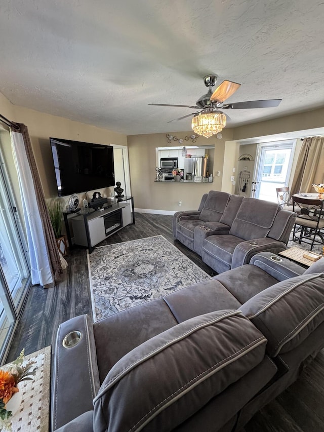 living room featuring a textured ceiling, dark hardwood / wood-style flooring, and ceiling fan