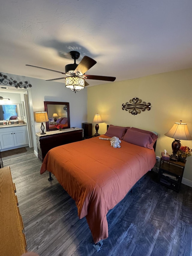 bedroom featuring ceiling fan, dark hardwood / wood-style floors, and connected bathroom