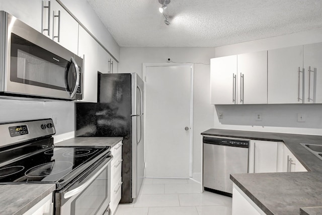 kitchen featuring a textured ceiling, white cabinets, stainless steel appliances, and track lighting