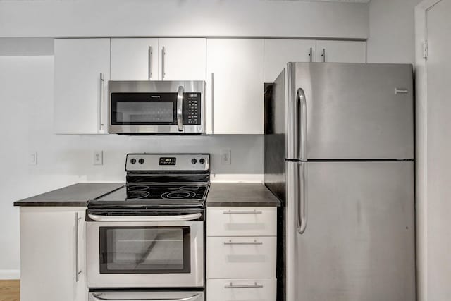 kitchen with white cabinets and appliances with stainless steel finishes