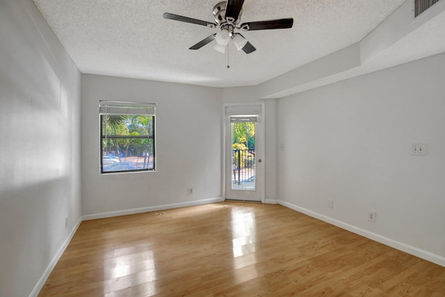 spare room with light wood-type flooring, a textured ceiling, and ceiling fan