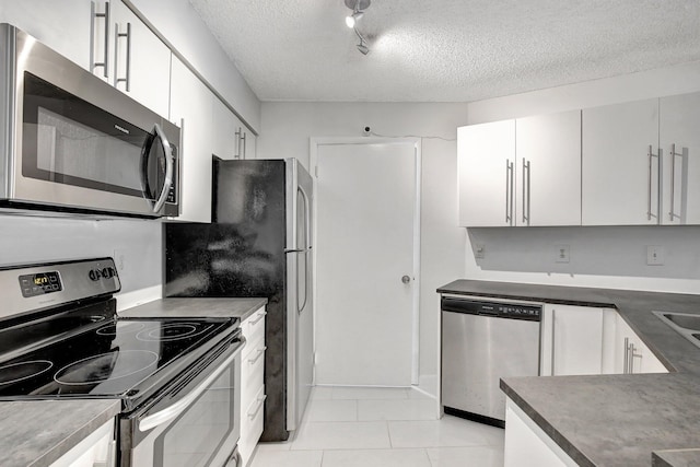 9999 Summerbreeze Dr Unit 1005, Sunrise, FL 33322 - kitchen with stainless steel appliances, a textured ceiling, dark countertops, white cabinets, and light tile patterned flooring