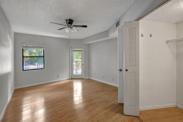 interior space with ceiling fan, a textured ceiling, and light hardwood / wood-style flooring