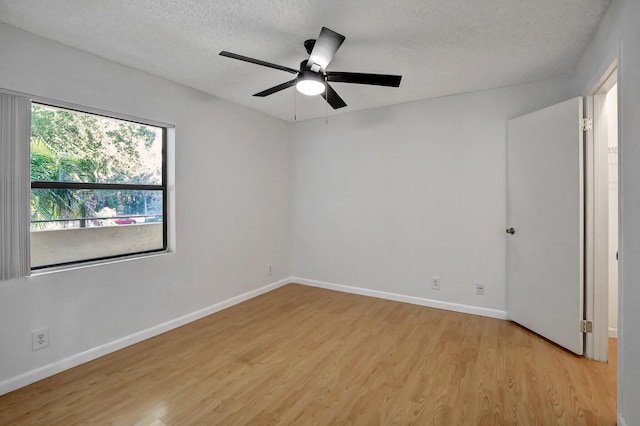 empty room with ceiling fan, light hardwood / wood-style floors, and a textured ceiling