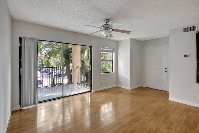 empty room with ceiling fan, light hardwood / wood-style floors, and a textured ceiling