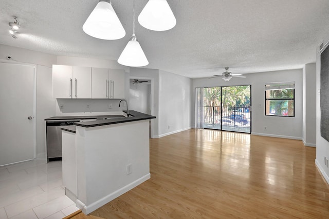 kitchen with dishwasher, white cabinets, sink, ceiling fan, and decorative light fixtures