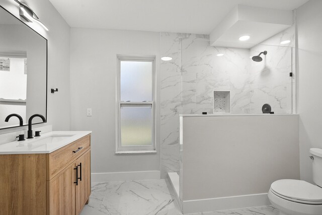 bathroom featuring a tile shower, sink, and toilet