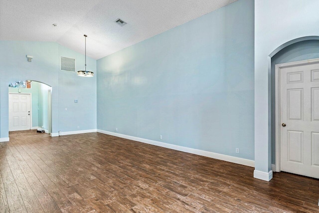 unfurnished living room with a textured ceiling, dark hardwood / wood-style flooring, and vaulted ceiling