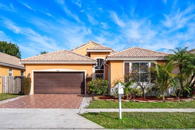 mediterranean / spanish house featuring a front yard and a garage