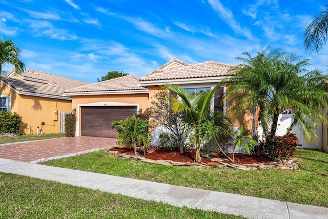 mediterranean / spanish house featuring a garage and a front yard