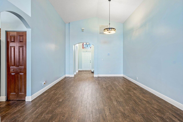 unfurnished room with dark wood-type flooring and high vaulted ceiling