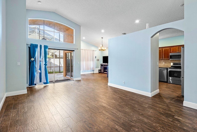 unfurnished living room featuring dark hardwood / wood-style floors, a textured ceiling, and vaulted ceiling