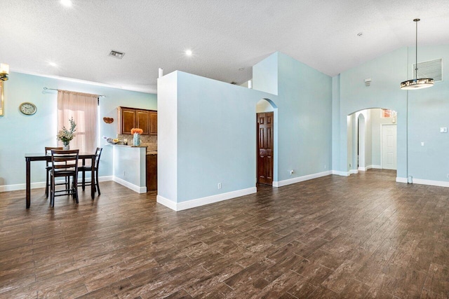 living room with a textured ceiling, vaulted ceiling, and dark wood-type flooring