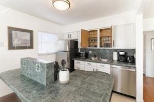 kitchen featuring tasteful backsplash, white cabinetry, sink, and appliances with stainless steel finishes