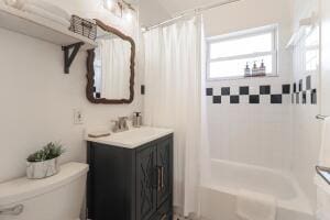 full bathroom featuring vanity, shower / tub combo, and toilet